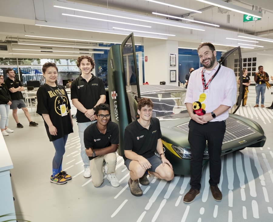 Richard with students by a solar car